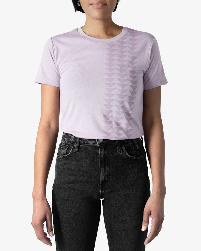Front view of a female model wearing a size X-Small Yaya Lavender Nakoa Tee from So iLL x On The Roam, tucked into black jeans