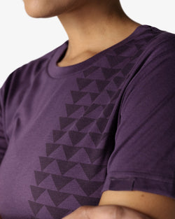 Close-up 3/4 view of the triangle pattern on the Unity Purple Nakoa Tee from So iLL x On The Roam, worn by a female model