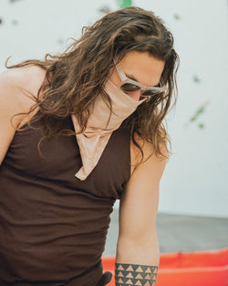 Jason Momoa wearing the Dirty Pink bandana and sunglasses in a climbing gym
